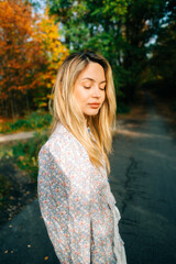 Portrait of attractive caucasian woman posing in the autumn park.