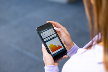 Woman watches stock prices and crashing stock index on her smartphone. Businesswoman with mobile phone in the hand. Dropping stock chart on the screen. Business and trading concept. 3D illustration