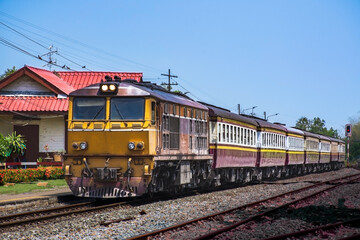 Fototapeta na wymiar Passenger train by diesel locomotive at the railway station. (Building is public)
