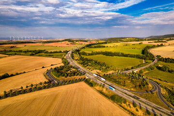 Aerial bird view of typical Ardennes green field meadows and hill landscape also showing highway...