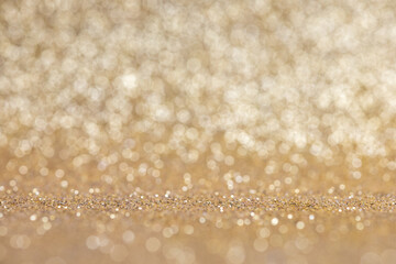 Glitter sparkling gold texture. Celebration bokeh blurred background. Selective focus, front view,...