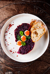 Layered salad with salmon, beets, carrots, onions, potatoes and eggs on a plate.
