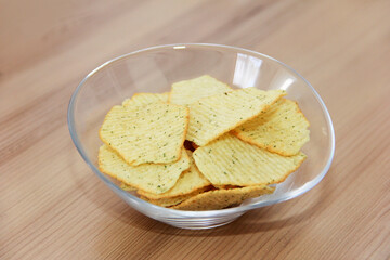 Yellow fried fluted potato chips in a decorative plate.