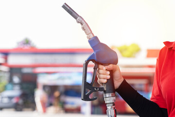Hands of attendant service male worker refuelling car at gas station. Assistant worker refuelling...