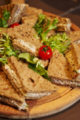 black bread sandwiches on a plate. light snacks. sandwiches for breakfast