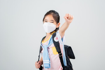 Asian little child girl carry a backpack wearing respirator mask to protect coronavirus outbreak...