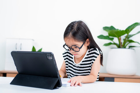 Asian child girl student wow excited on video call learning to studying online class or person learn from home school with tablet