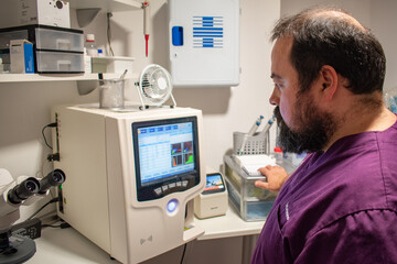 Veterinarian in the laboratory looking at analysis results on a screen.