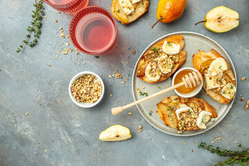 Pear and brie crostini with honey, walnut and thyme, New Years Eve or Christmas party appetizer. banner, menu, recipe place for text, top view