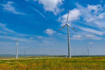 Obraz premium huge wind generators in nature. Green clean energy. Conservation of natural resources thanks to windmills