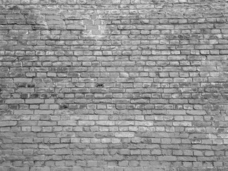 An old black and white brick wall. Historical horizontal monochrome brickwork for wallpaper and surface design.