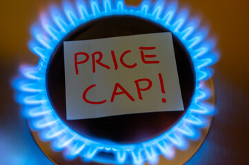 Fornello del gas acceso, con scritta Price Cap. Introduzione del limite al prezzo del gas in Europa.
