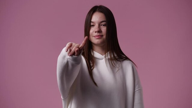 4k slow motion video of one girl gesturing no over pink background.