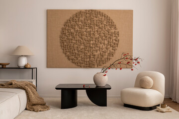 Creative composition of living room interior with mock up poster frame, black coffee table, bowl, vase with dried flowers, beige rug, wooden sculpture and personal accessories. Home decor. Template.