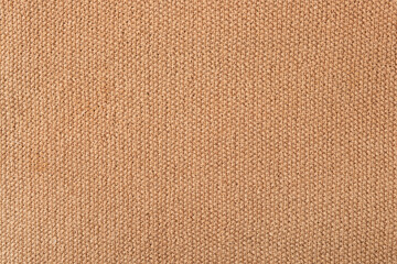 Knitted beige background. Large knitted fabric with a pattern. Close-up of a knitted blanket. Horizontal ornament.