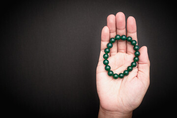 Jade bangles or bracelets in hand against a black background