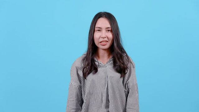 4K, portrait, Woman with long hair wearing striped shirt, He raised both his arms and made a mocking gesture, I don't know, I don't care about this, Isolated indoor studio on blue background.