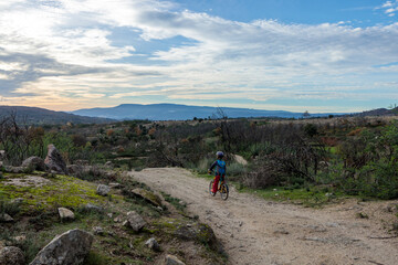 Fototapeta premium Child Cycling Through the Stunning Sierra Estrella Mountain Range in Portugal