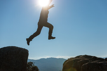 man jumping on the top of the mountain