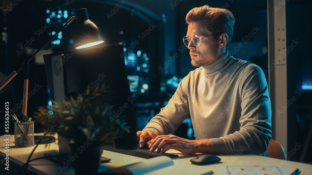 Poster Portrait of a Stylish Male Working on Desktop Computer in a Company Office in the Evening. Young Manager Browsing Internet, Shopping Online and Reading Social Media Posts from Friends and Colleagues.
