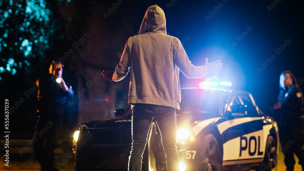 Wall mural Two Police Officers Aim at a Civilian. Police Using a Weapon Against a Non-Violent Person. Camera Focus on Suspect Raising Hands in Compliance. Escalated Situation due to Police Brutality