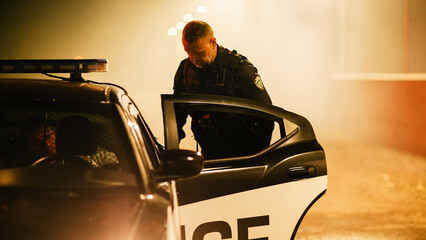 Middle Aged Cop Putting Criminal in Police Patrol Car. Professional Male Officer of the Law...