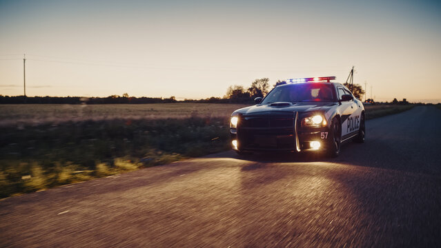 Highway Traffic Patrol Car In Pursuit of Criminal Vehicle. Police Officers in Squad Car Chase Suspect on Industrial Area Road. Criminal Crashes Boxes. Cinematic Atmospheric High Speed Action Scene