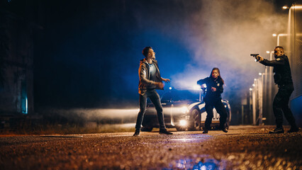 Two Police Officers in Pursuit of a Suspect on Foot. Cops Getting out of the Car Chase Criminal Through the Dark City Streets. Heroic Officers of the Law Fight Crime. Cinematic Low Angle © Gorodenkoff