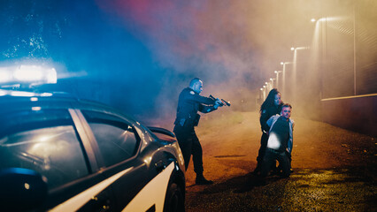 Professional Police Officer Aim at a Suspect While Black Female Deputy Handcuffs him. Fellon Putting Hands on Head in Compliance. Police Successfully Making an Arrest and Keeping the City Safe © Gorodenkoff