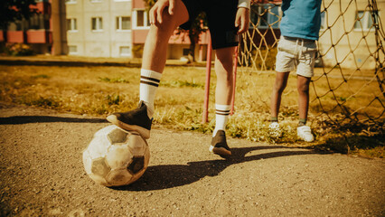 Close Up Shot : Young Boy Stopping a Ball with his Foot. Young Football Players Getting Ready to play Soccer in Neighborhood Pitch. Enjoying Childhood with Sports, Action and Happy Friendships