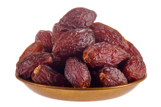A pile of dates lies in a copper plate. Isolated on transparent background