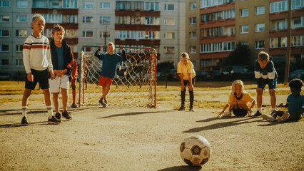 Portrait of a Young Handsome Boy Making a Penalty Kick During a Friendly Neighborhood Soccer Match with Local Kids. Talented Football Player Practicing Free Kicks in the Backyard. © Gorodenkoff