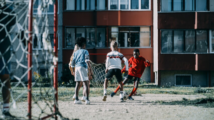 Multiethnic Diverse Friends Playing Soccer Outside in Urban Backyard. Young African American Boy Dribbling, Passing Opponents Alone with the Ball and Scoring a Goal. Cold Desaturated Color Grading.