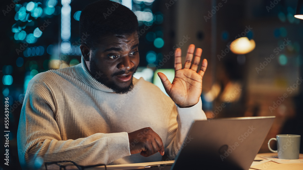 Poster portrait of a handsome black project manager making a video call on laptop computer in an evening of