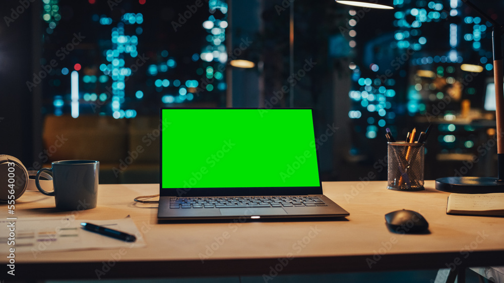 Aufkleber laptop standing on a desk with a green screen chromakey mock up display. table with computer, coffee