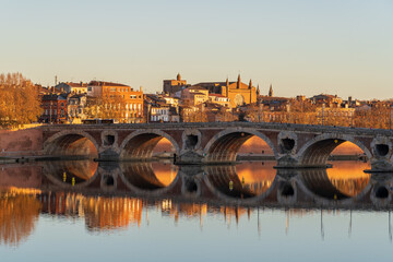 Scenic autumn sunset view of the Pont Neuf or New Bridge on the Garonne river in the famous pink city of Toulouse, France