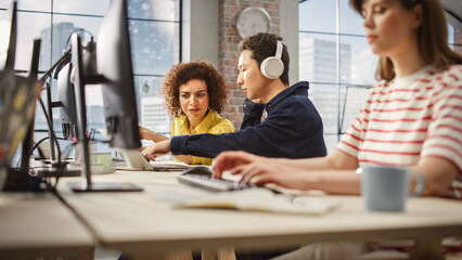Group of Colleagues Working On Computers in Office. Female Biracial Help Desk Coordinator Collaborates with Asian Male Customer Service Agent with headophones,