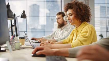 Portrait of Biracial Inspired Young Woman Smiling and Using Laptop in Bright Contemporary Office. Client Advisor Answering Customer Support emails. Team Working on Problem Solving in the Frame