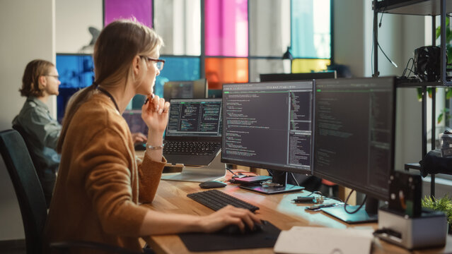 Professional Female Backend Software Developer Coding on Desktop Computer With Two Displays in Creative Office.Caucasian Woman Creating User Data Base for New Social Network Website or Online Store.