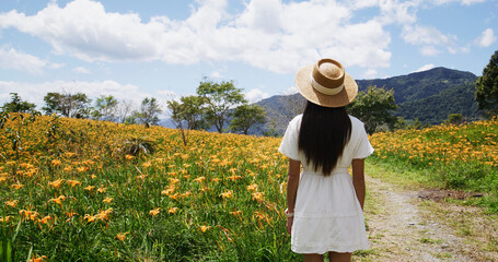 Tourist woman visit Taimali with beautiful Orange day lily flower