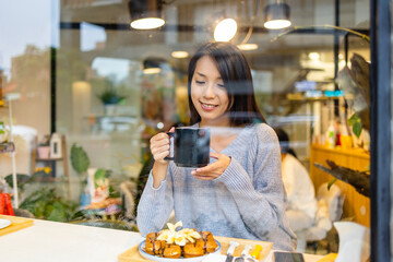 Woman enjoy her coffee and sit inside the coffee shop