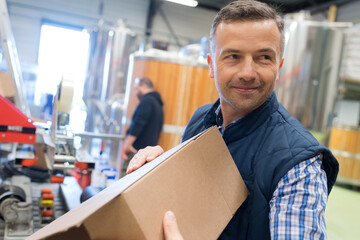 man holding cardboard box in factory dispatch department