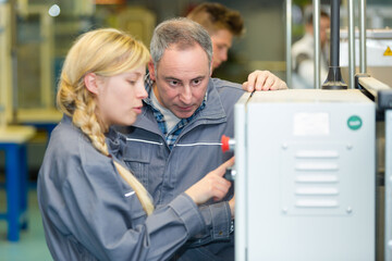 engineer training female apprentice on milling machine