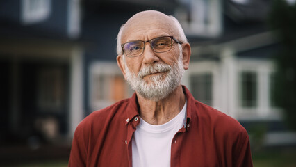 Portrait of a Happy Senior Man with Gray Hair Wearing Glasses and a Red Shirt Standing Outside in...