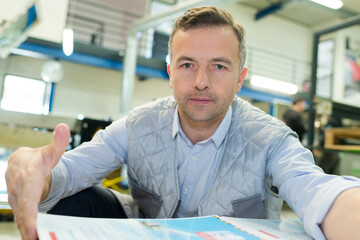 working man tidying papers in industrial premises