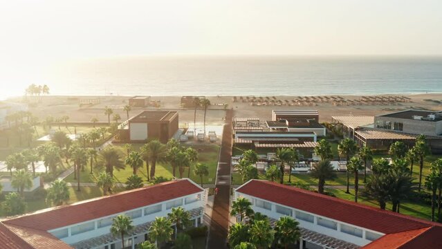 Cinematic shot of beach Resort during Golden Hour. Drone shot flying towards the empty beach before sunset.
Soft warm sunshine.
Santa Maria in Sal - Cape Verde.