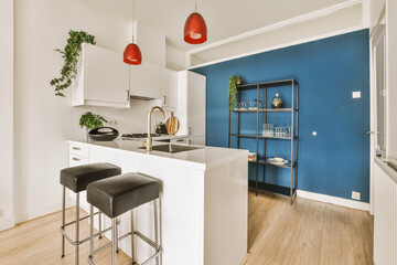 a kitchen and dining area in a house with blue walls, hardwood flooring and white cabinetd cupboards