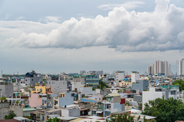 Obraz premium HO CHI MINH, VIETNAM - December 3, 2022: Slum wooden house on the Saigon river bank, in front of modern buildings in ho chi minh city. View to district 1, see Bitexco tower, Landmark 81.