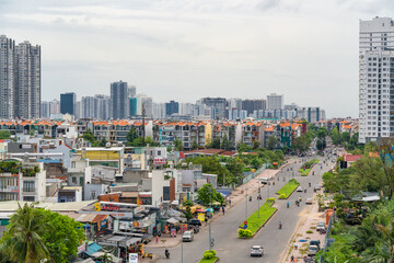 HO CHI MINH, VIETNAM - December 3, 2022: Slum wooden house on the Saigon river bank, in front of modern buildings in ho chi minh city. View to district 1, see Bitexco tower, Landmark 81.