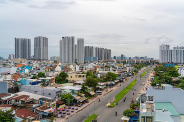 HO CHI MINH, VIETNAM - December 3, 2022: Slum wooden house on the Saigon river bank, in front of modern buildings in ho chi minh city. View to district 1, see Bitexco tower, Landmark 81.